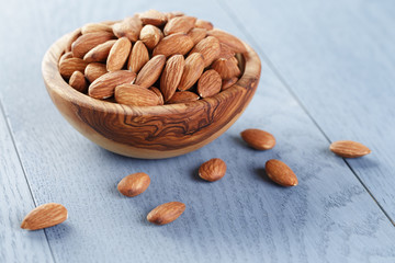 roasted almonds in bowl on blue wooden table