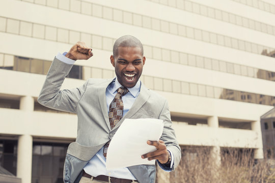 Successful man celebrates success holding new contract documents
