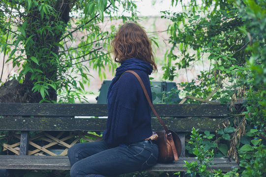 Woman sitting on bench in forest