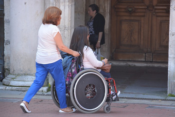 mujer empujando una silla de ruedas