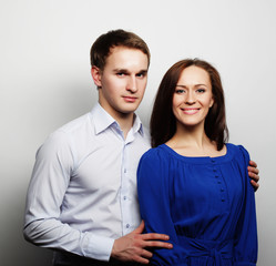 lovely happy couple hugging over grey background.