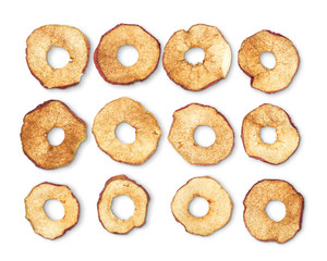 Dried apple rings sprinkled with cinnamon on white background.