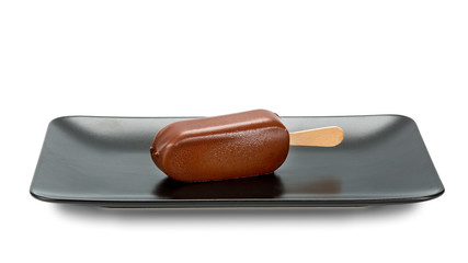 Chocolate ice lolly served on a black plate.