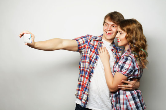 smiling couple with smartphone, selfie and fun. 