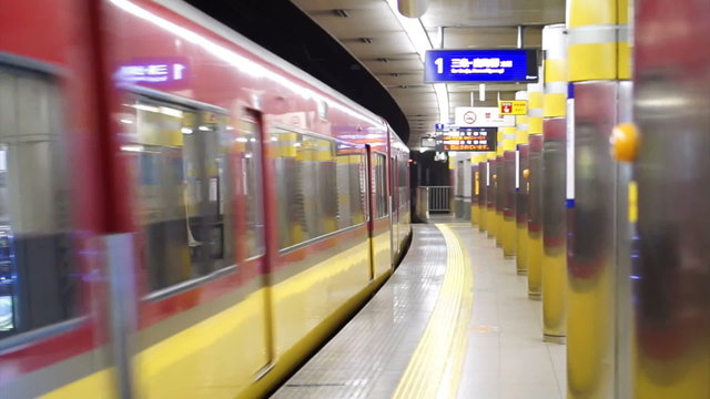 Osaka, Japan - MARCH 2015: Train running through subway station's platform with no people standing 