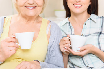 Grandmother and granddaughter with cups 