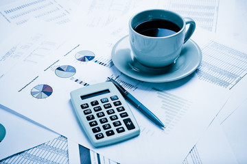 Business report. Cup of coffee on document. Accounting