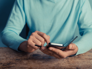 Man at table using smart phone