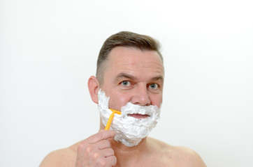 Mann rasiert sich seinen Bart mit Rasierschaum