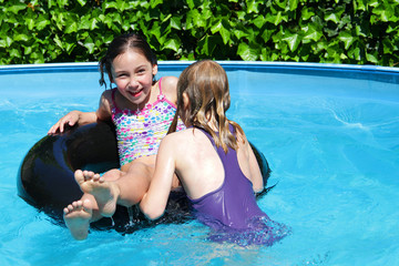 Mädchen spielen im Swimmingpool