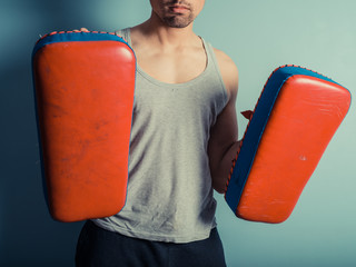 Athletic young man with martial arts pads © LoloStock