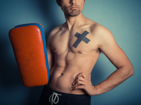 Athletic young man with martial arts pads
