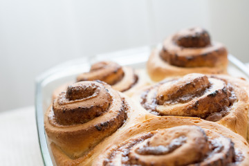 Homemade cinnamon buns (cinnabons) in glass dish, close up