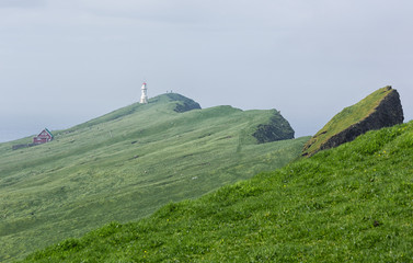 Lighthouse and scenic landscape on Faroe islands.