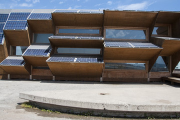 Public building made of solar panels, wood and mirror glass