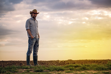 Male Farmer Standing on Fertile Agricultural Farm Land Soil