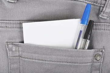 Denim pocket with two pens and a piece of paper