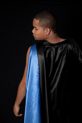 Black man in black and blue cape