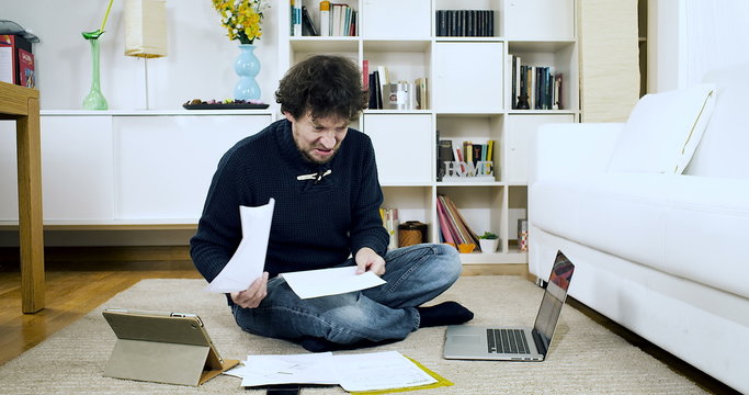 Man crying about bills and taxes at home