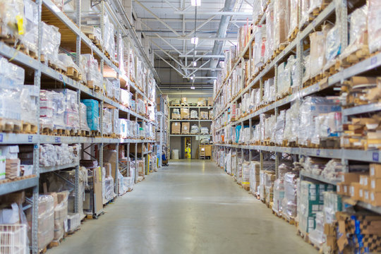 Rows of shelves with boxes and other goods in modern warehouse