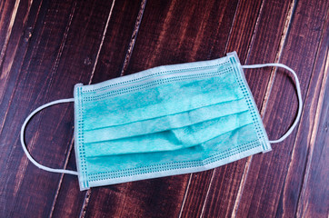 disposable face mask on wooden background