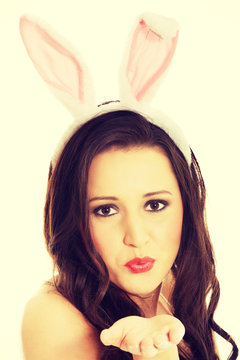 Woman wearing bunny ears and blowing a kiss