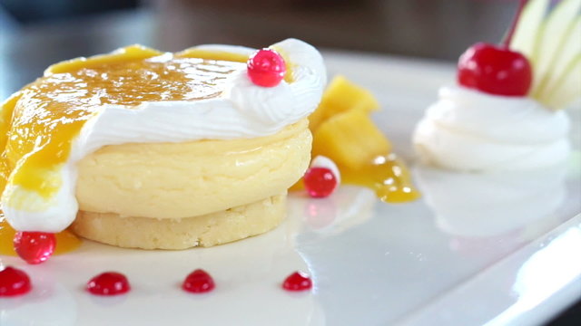 Eating Mango Cheese Cake on white plate with fresh fruit decoration