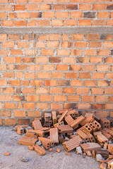 pile of bricks in construction site with brick wall background