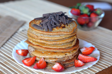 Stack of sweet pancakes with strawberries and cinnamon sugar and chocolate