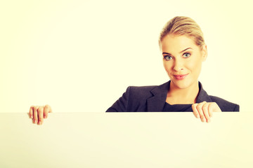 Businesswoman holding empty billboard