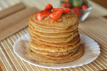 Stack of sweet pancakes with strawberries and cinnamon sugar 