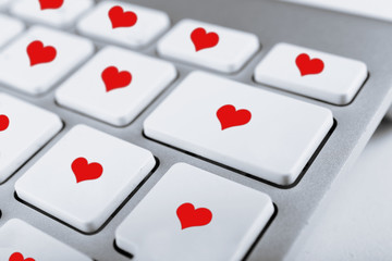 Close up of laptop keyboard with hearts icons