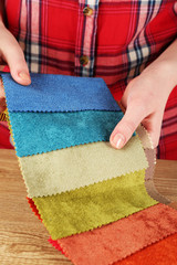 Woman chooses scraps of colored tissue on table close up