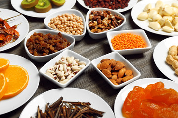 Different products on saucers on wooden table, closeup