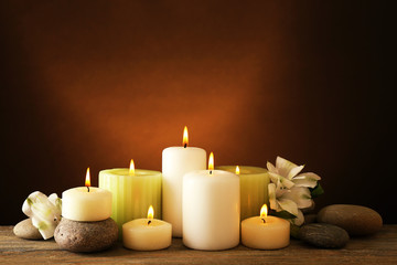 Fototapeta na wymiar Beautiful composition with candles and spa stones on dark background