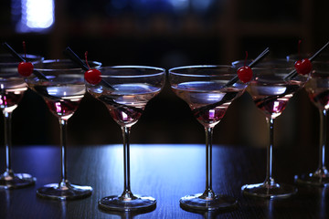 Glasses of cocktails on bar background