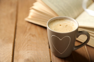 Still life with cup of coffee and book, on wooden table
