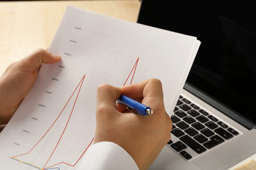 Businessman analyzing charts, closeup