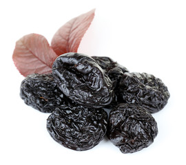 Pile of prunes with leaves isolated on white