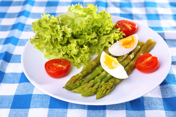 Plate of dietary salad with boiled asparagus and egg, closeup