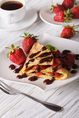 crepes with strawberries and coffee close-up. Vertical
