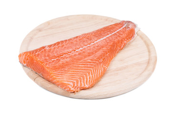 Raw salmon fillet on wood platter.
