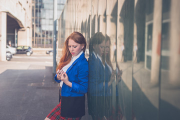 Beautiful redhead girl posing in an urban context
