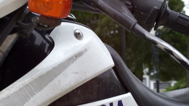 Close up tilt up shot of a police motorbike marked policia in spanish and the flashing red and blue lights that are attached to the motorcycle.