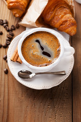 Fresh croissants and cup of coffee on a table