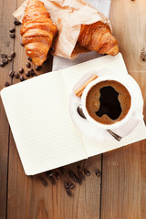 Fresh croissants and cup of coffee on a table