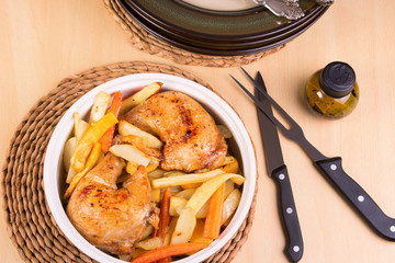 Roasted chicken legs and vegetables in a casserole, pile of plat