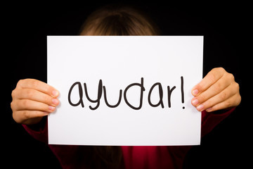 Child holding sign with Spanish word Ayudar - Help