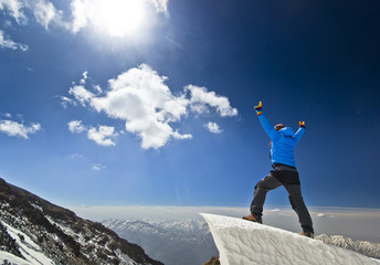 man standing on a snow cornice in mountain sunrise