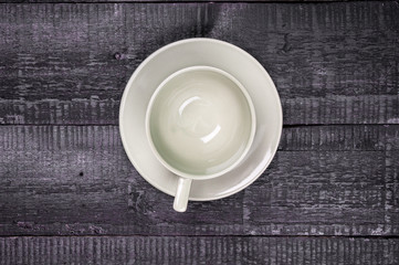 Empty cup with saucer on wooden background